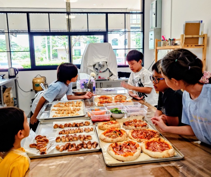 Children at the studio table making their own small pizzas and bread rolls